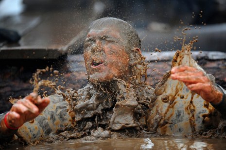 A-competitor-in-fancy-dress-emerges-from-muddy-water-during-the-Tough-Guy-Challenge-endurance-race-in-Perton-England-on-January-29-2012.-Every-year-thousands-of-people-run-the-8-mile-assault-course-which-inv